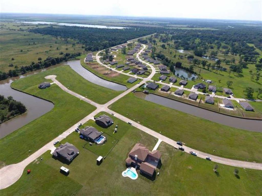 an aerial view of a tennis ground and a cars park side of the ocean