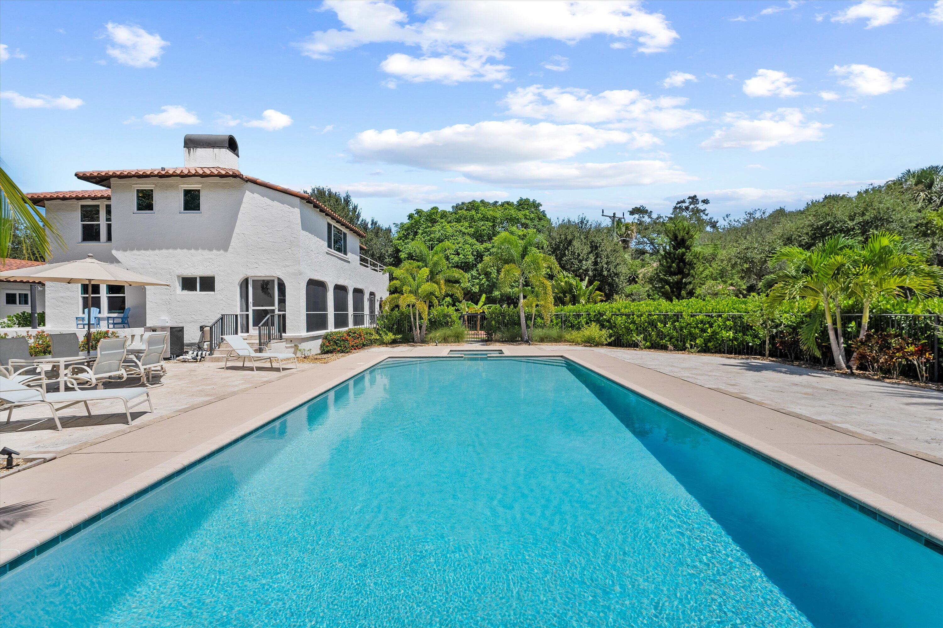 a view of a house with swimming pool and sitting area