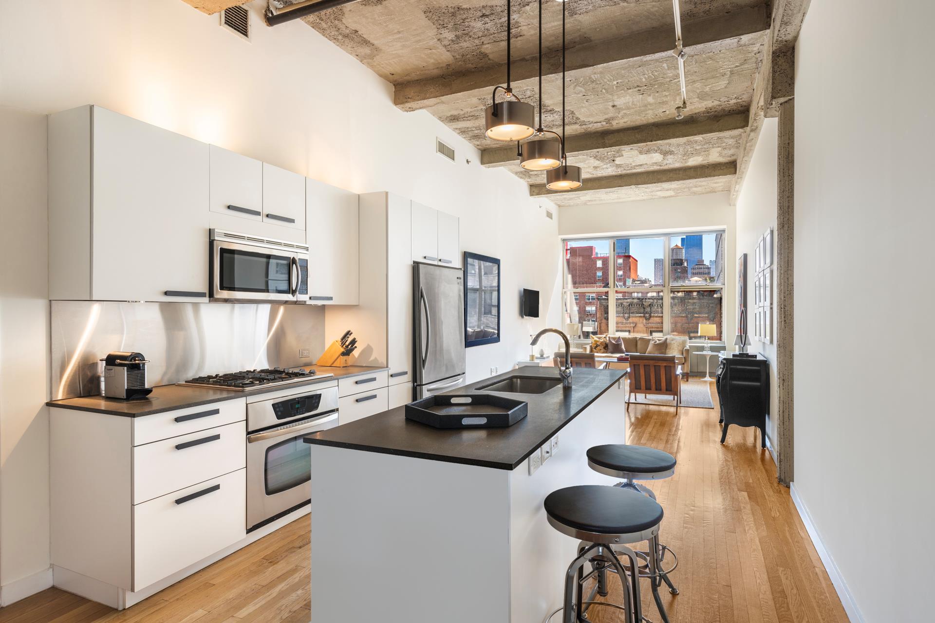 a kitchen with stainless steel appliances kitchen island granite countertop a stove a sink and a refrigerator