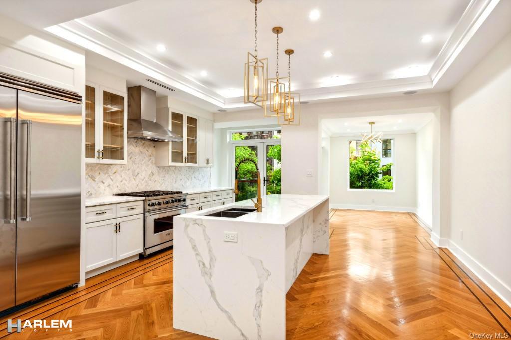 a kitchen with kitchen island granite countertop a stove a sink a center island and stainless steel appliances