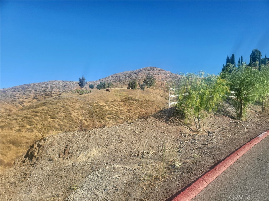 a view of a dry yard with mountains in the background