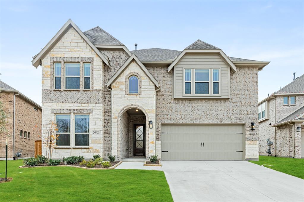 a front view of a house with a yard and garage