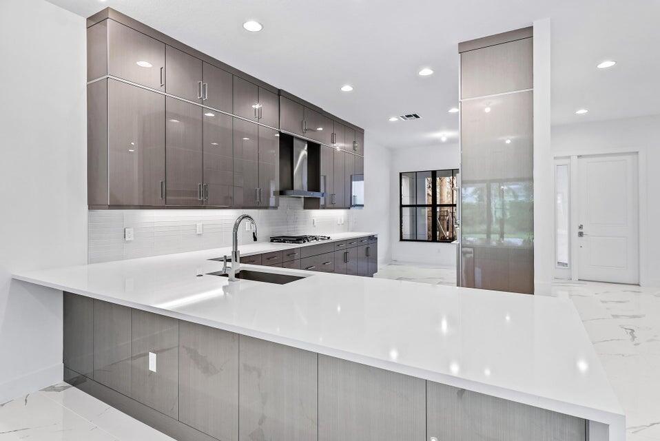 a large kitchen with stainless steel appliances a large counter top