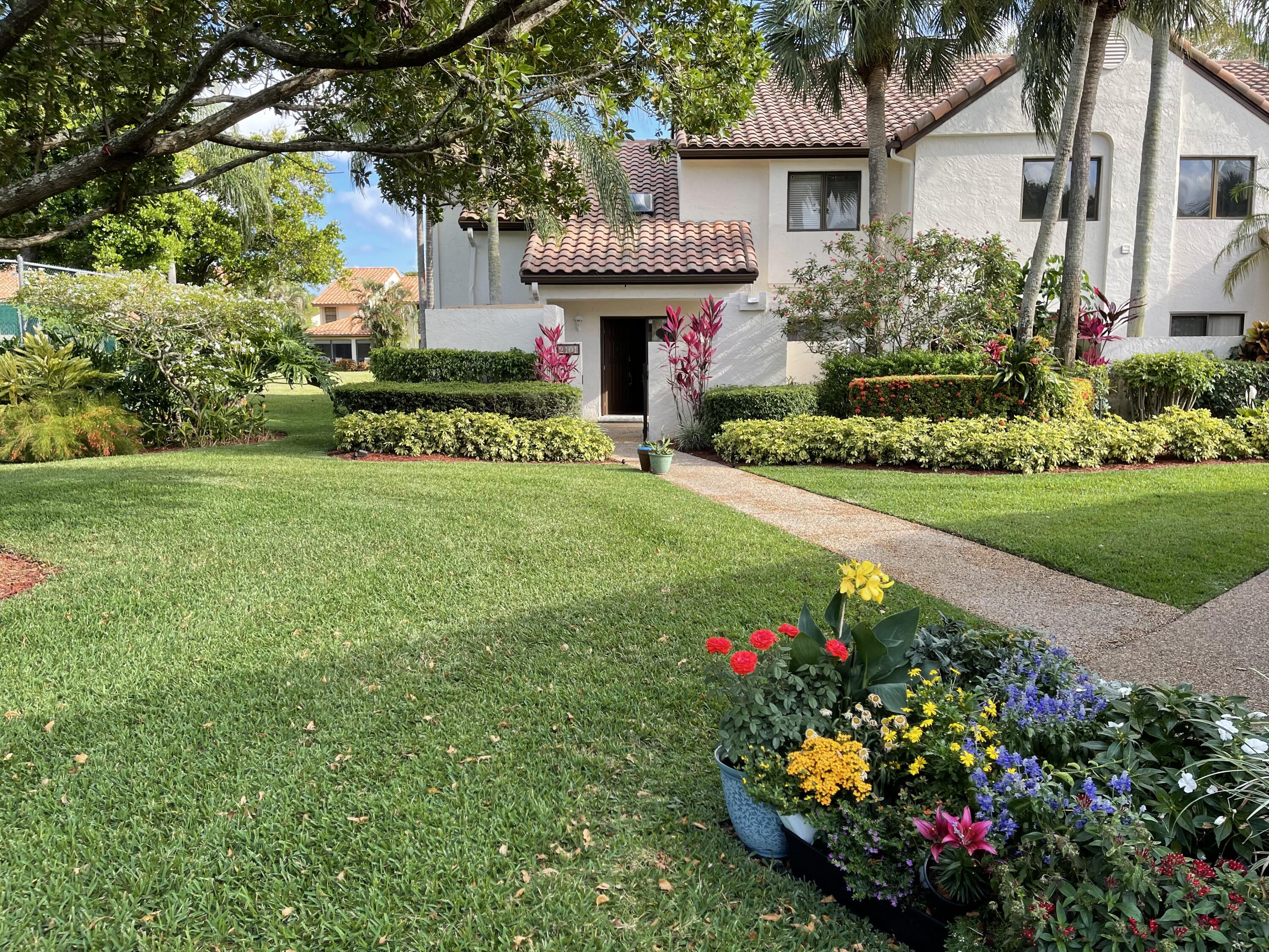 a front view of a house with a big yard and a fountain