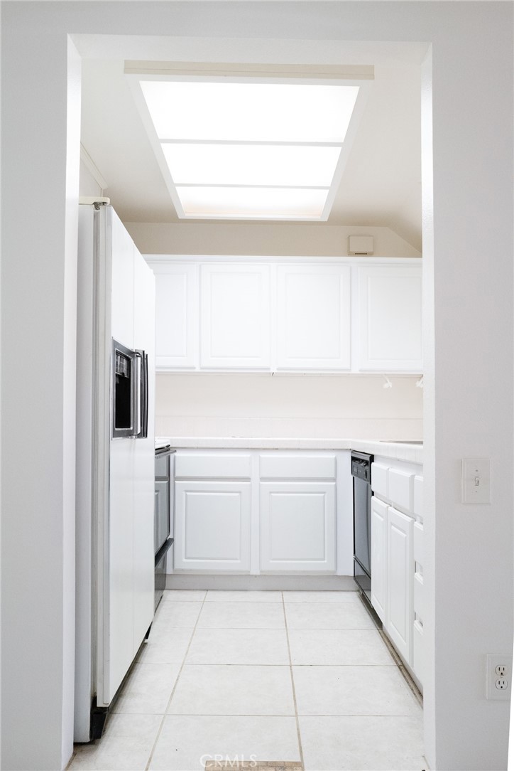 a kitchen with white cabinets and white appliances