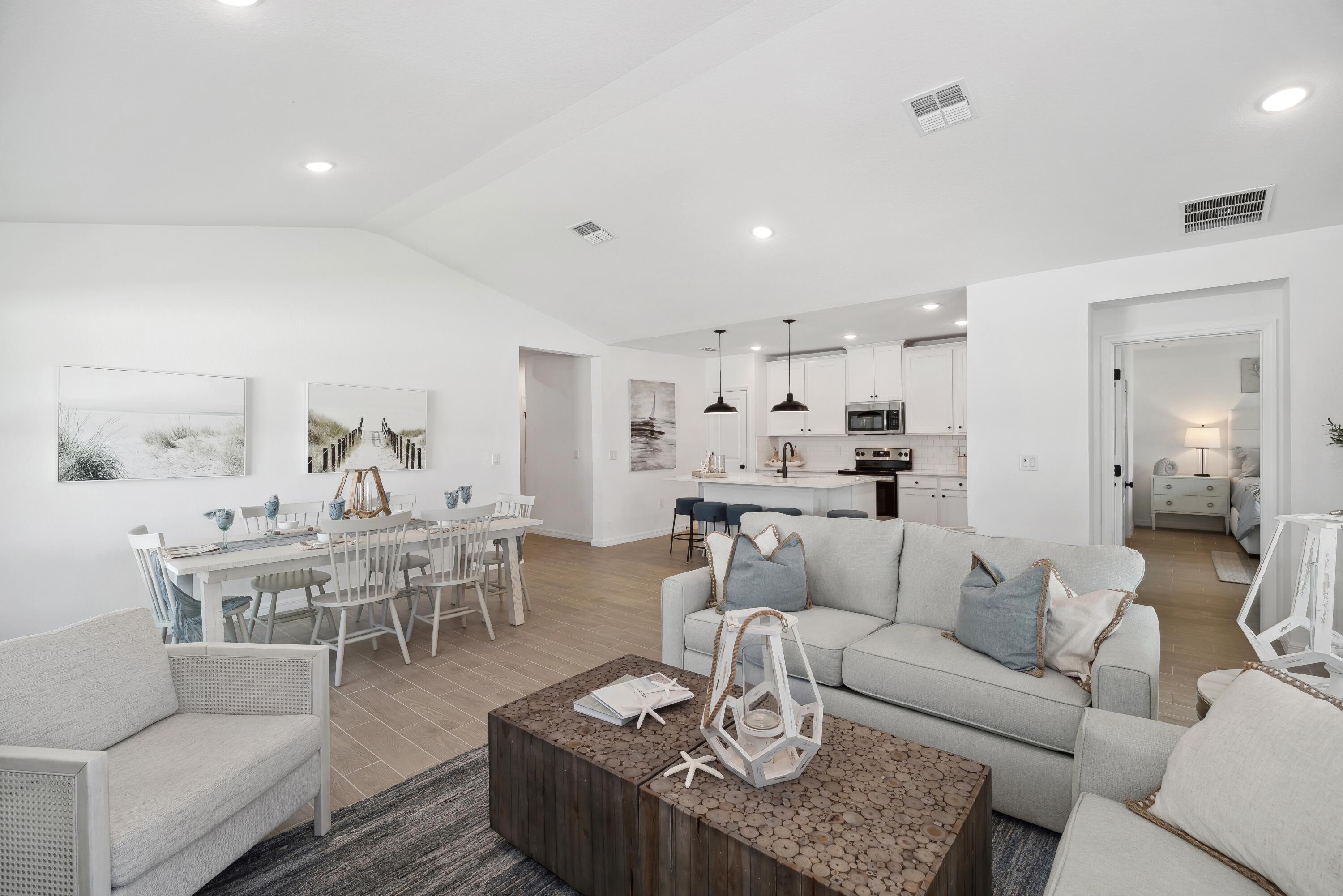 a living room with furniture wooden floor and a dining table