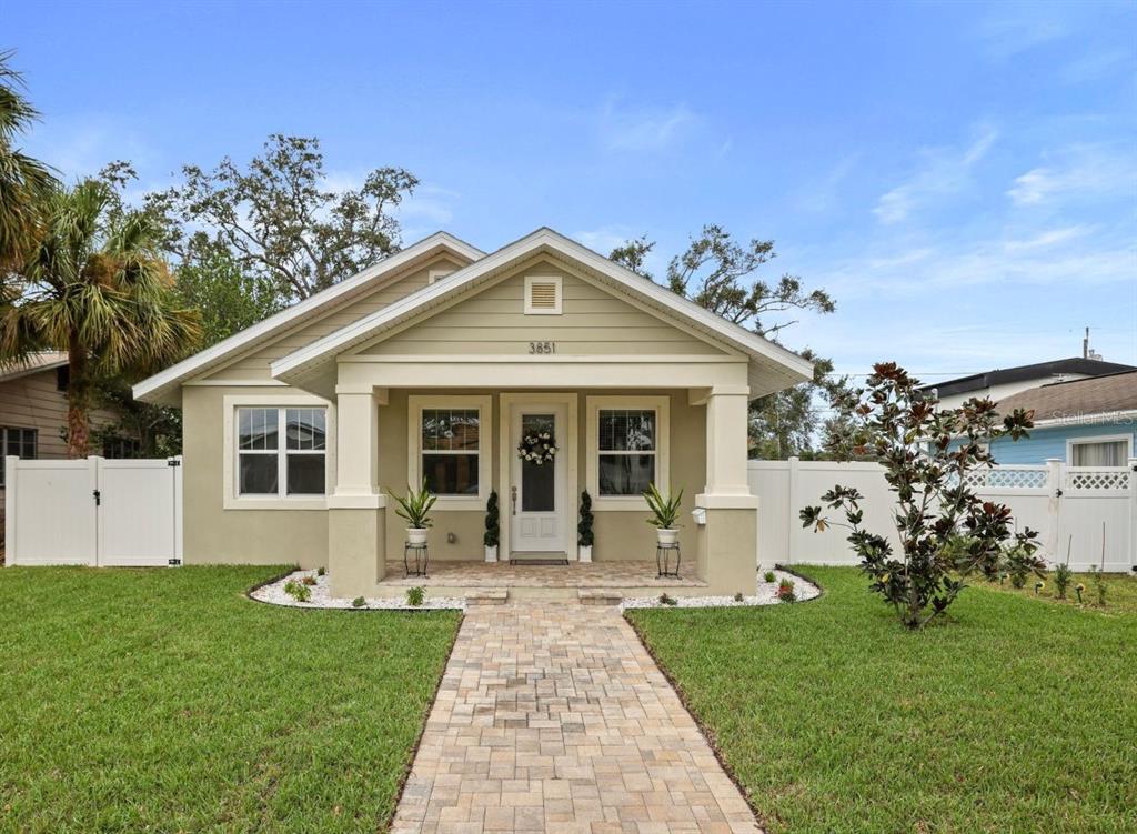 a front view of a house with a garden and plants