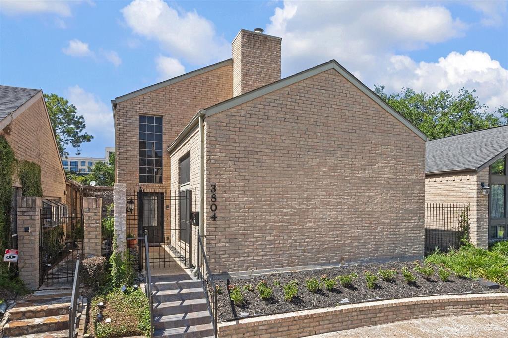 a brick house with a yard and plants