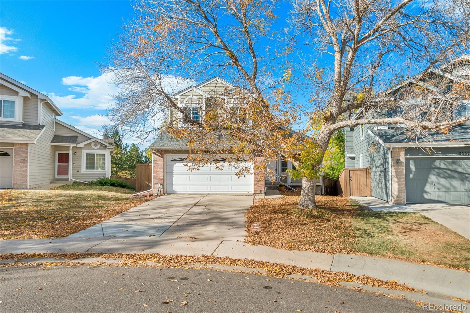 a view of a house with a yard and large tree