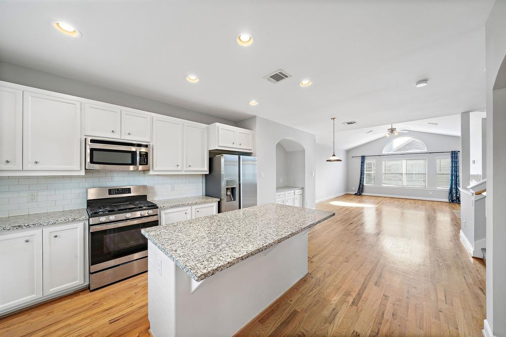 a kitchen with granite countertop a stove and a refrigerator