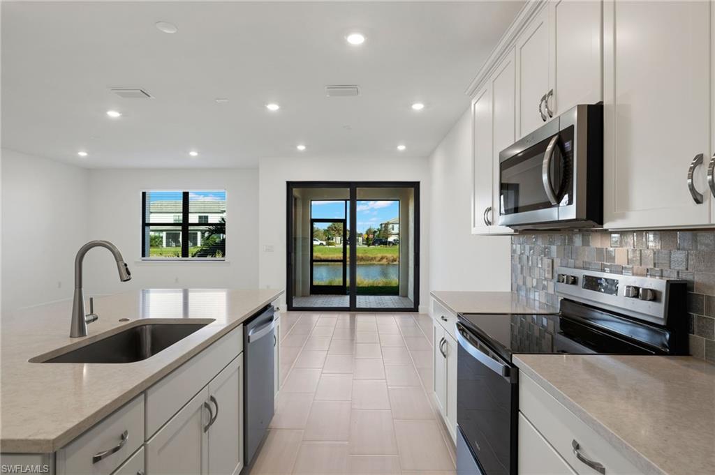 a kitchen with stainless steel appliances granite countertop a sink and a microwave