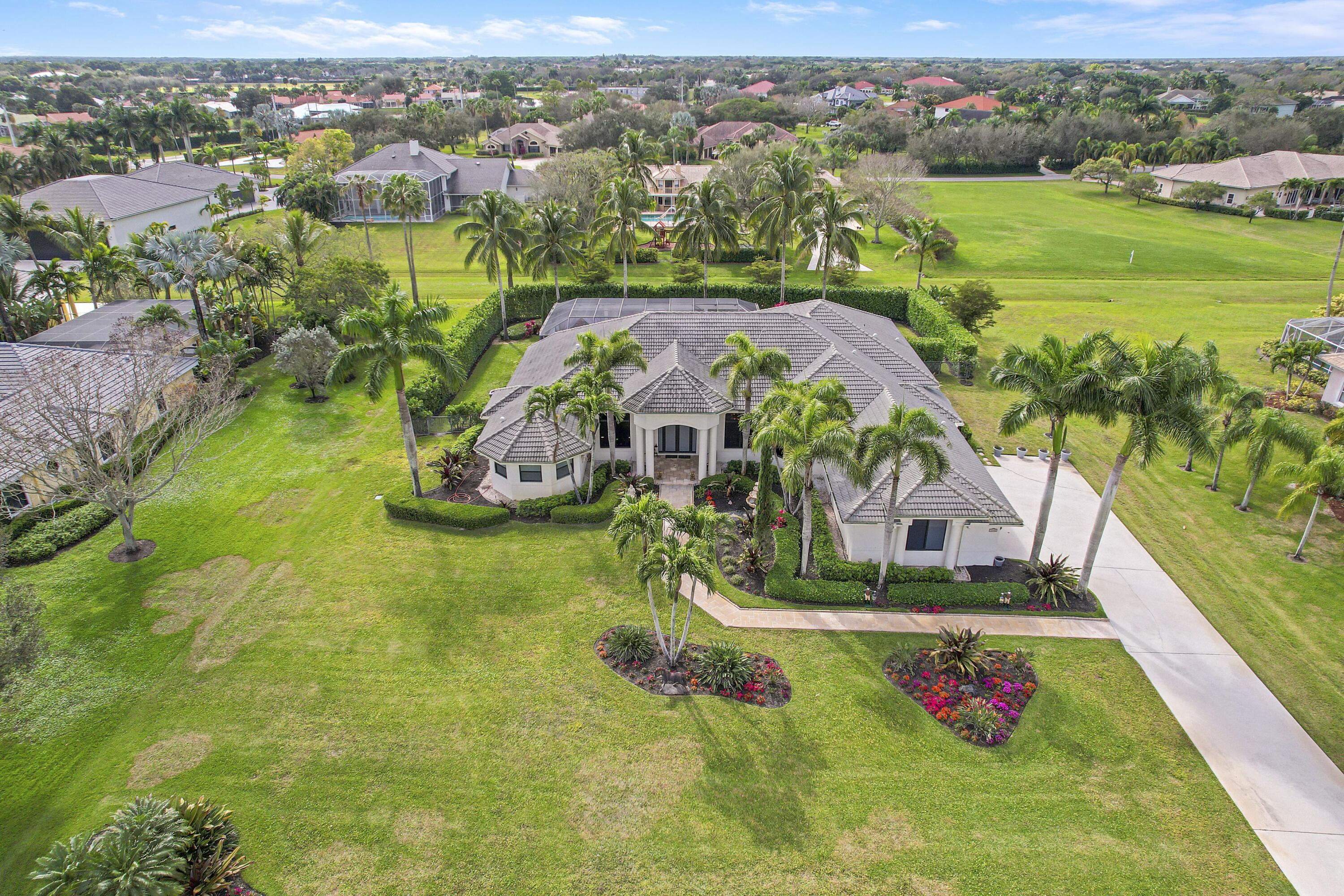 an aerial view of residential houses with outdoor space and trees