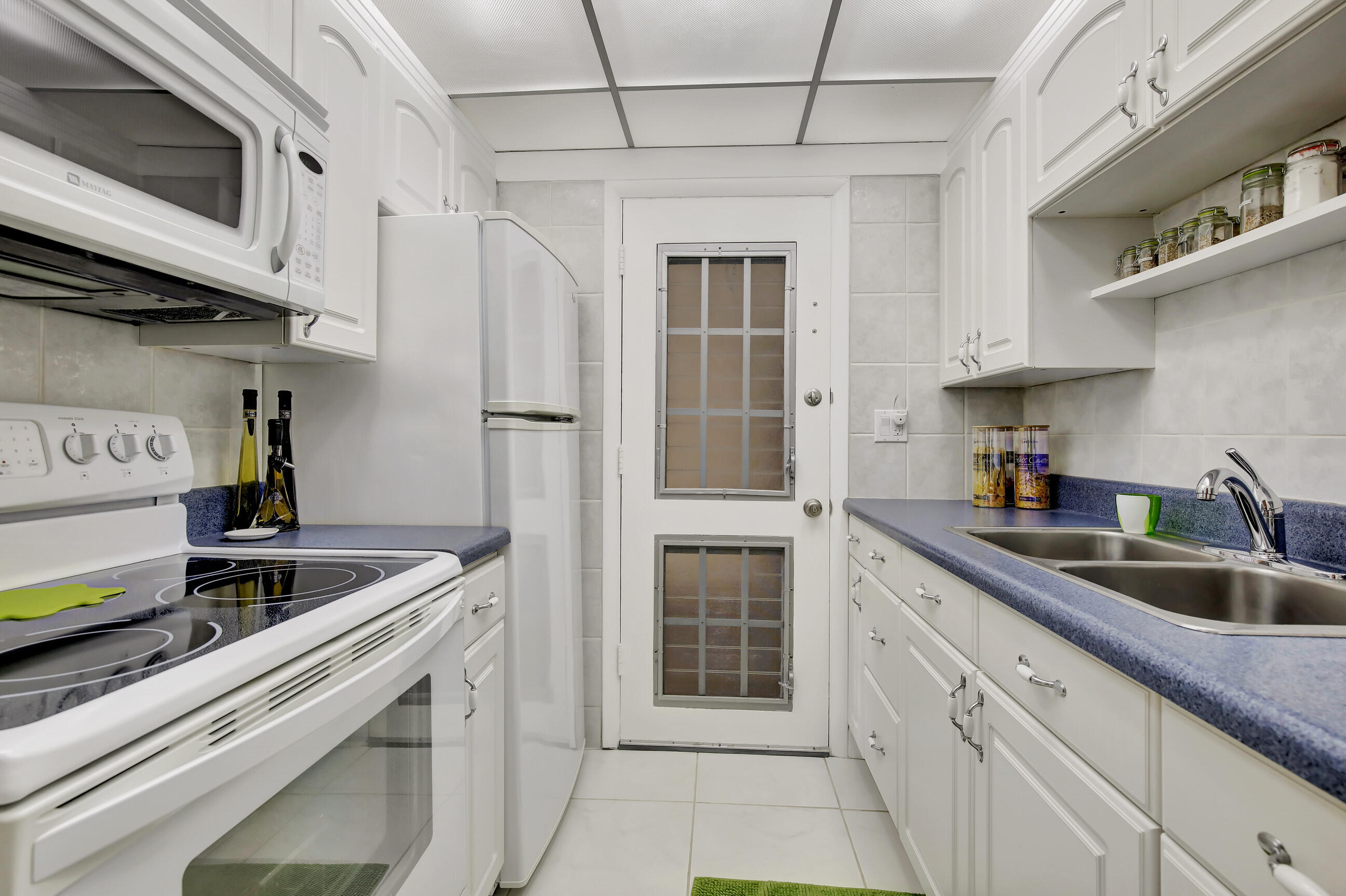 a kitchen with stainless steel appliances granite countertop a sink and a refrigerator