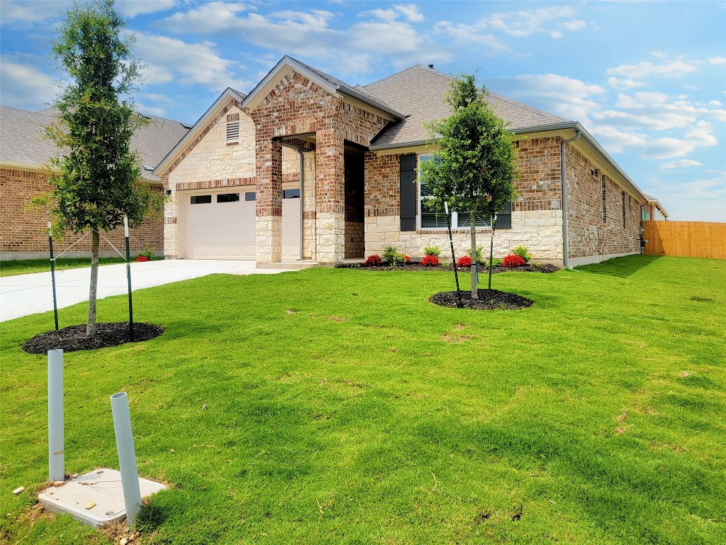 a view of a house with backyard and a garden