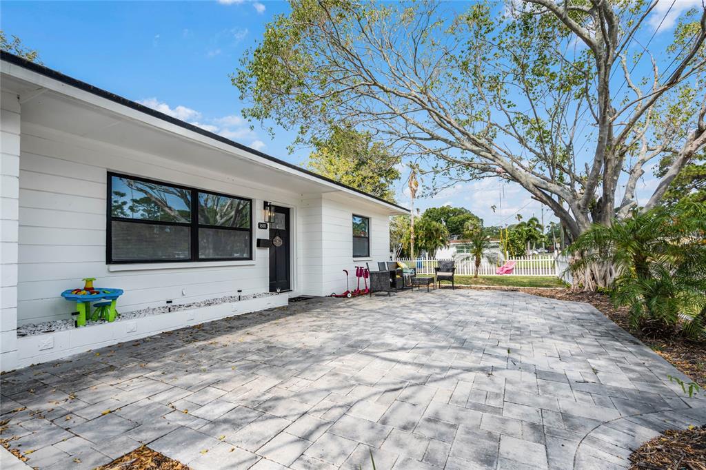 a view of a house with backyard and a tree