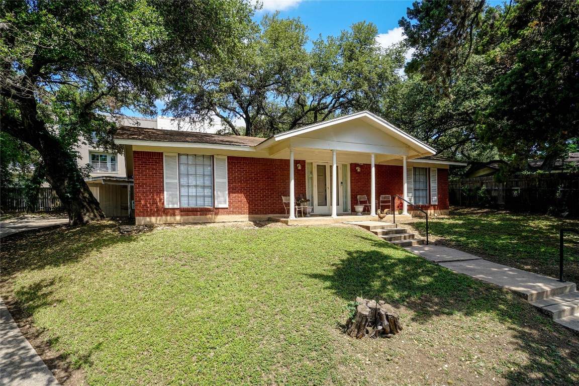 a front view of a house with a yard porch and outdoor seating