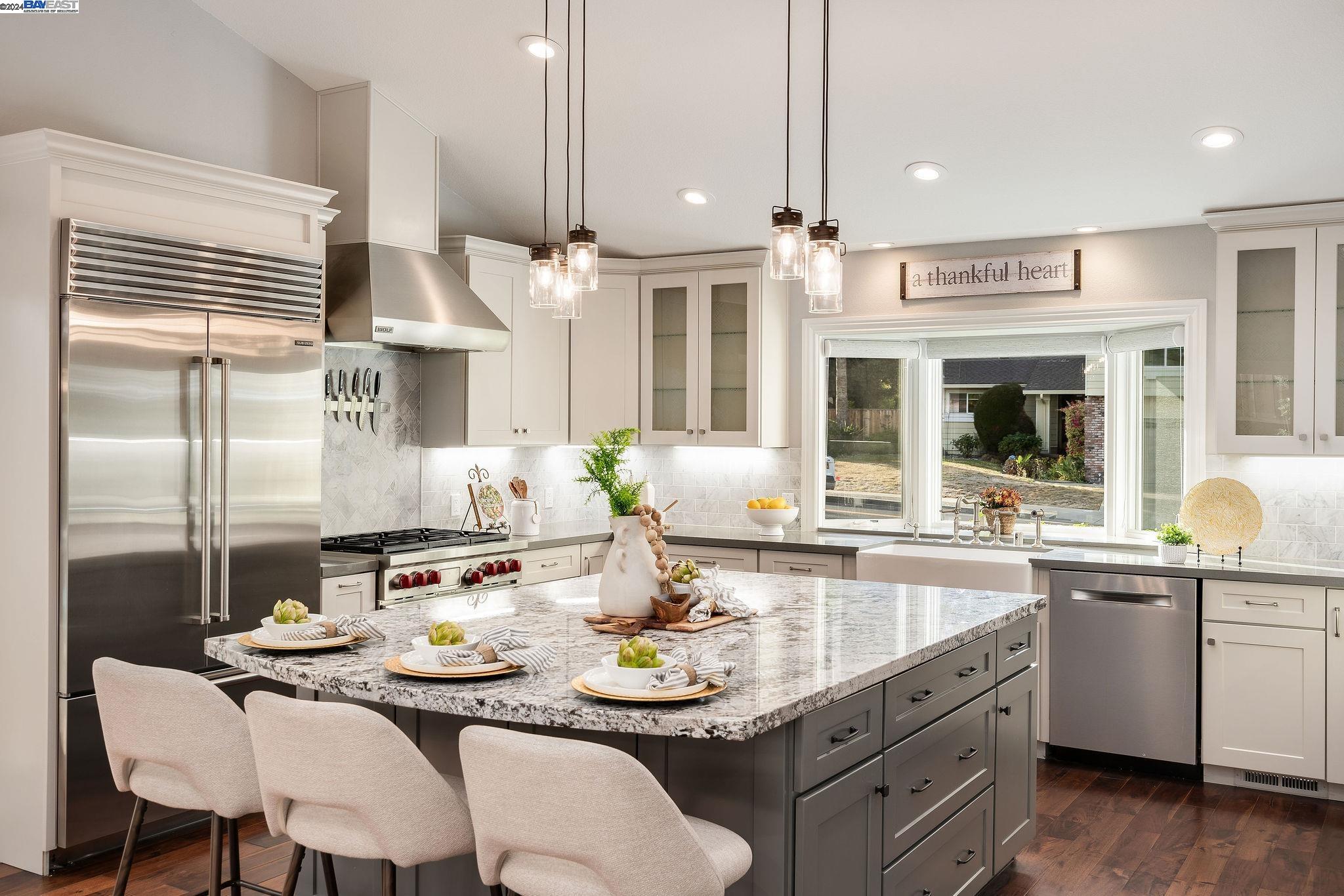 a kitchen with granite countertop a sink cabinets and stainless steel appliances