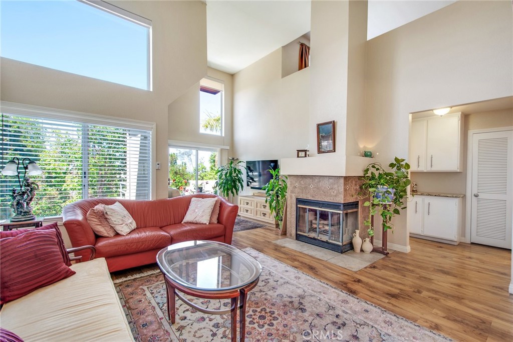 a living room with furniture a fireplace and a large window