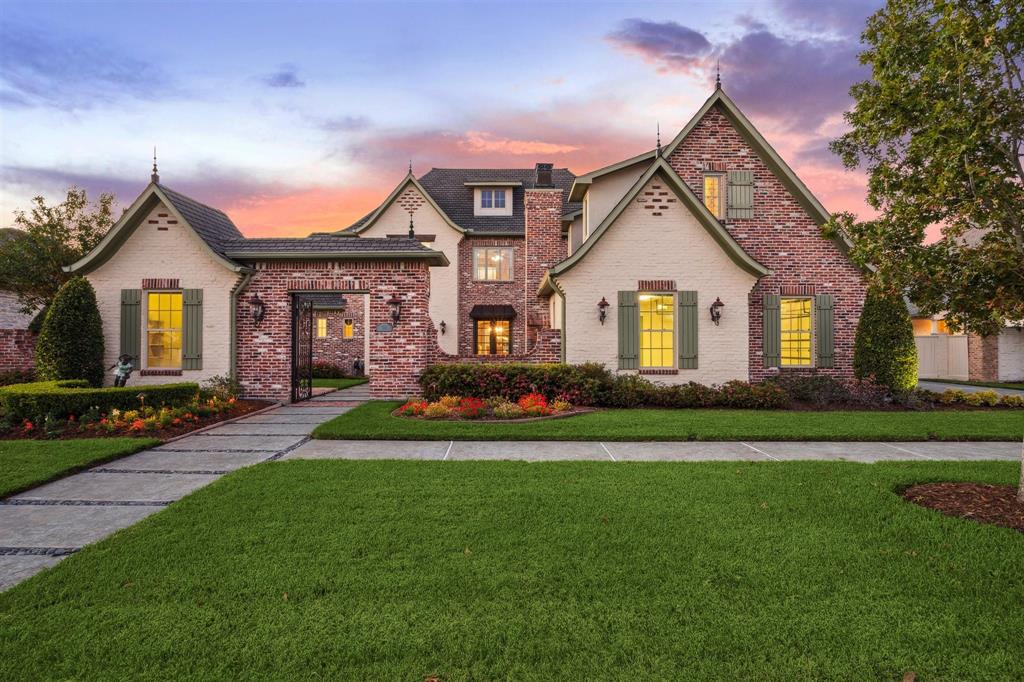 a front view of a house with a garden and yard