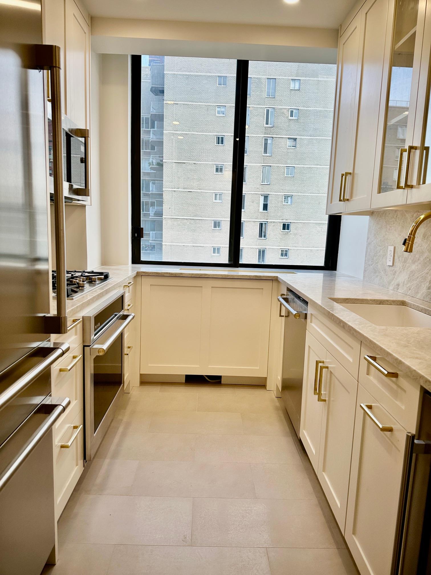 a view of a kitchen with stainless steel appliances cabinets and a window