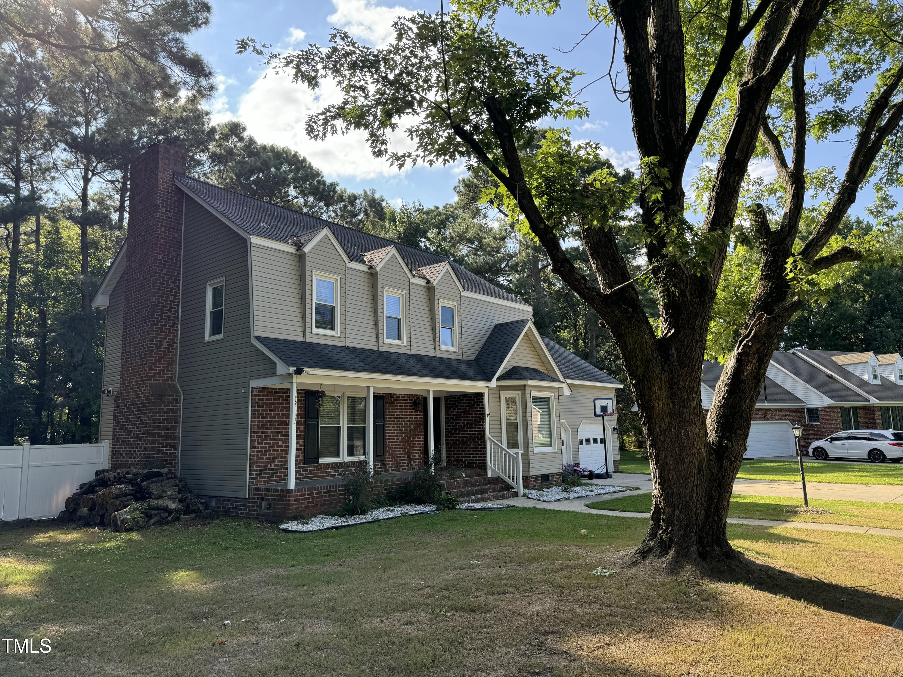 a view of a yard in front of a house with large tree