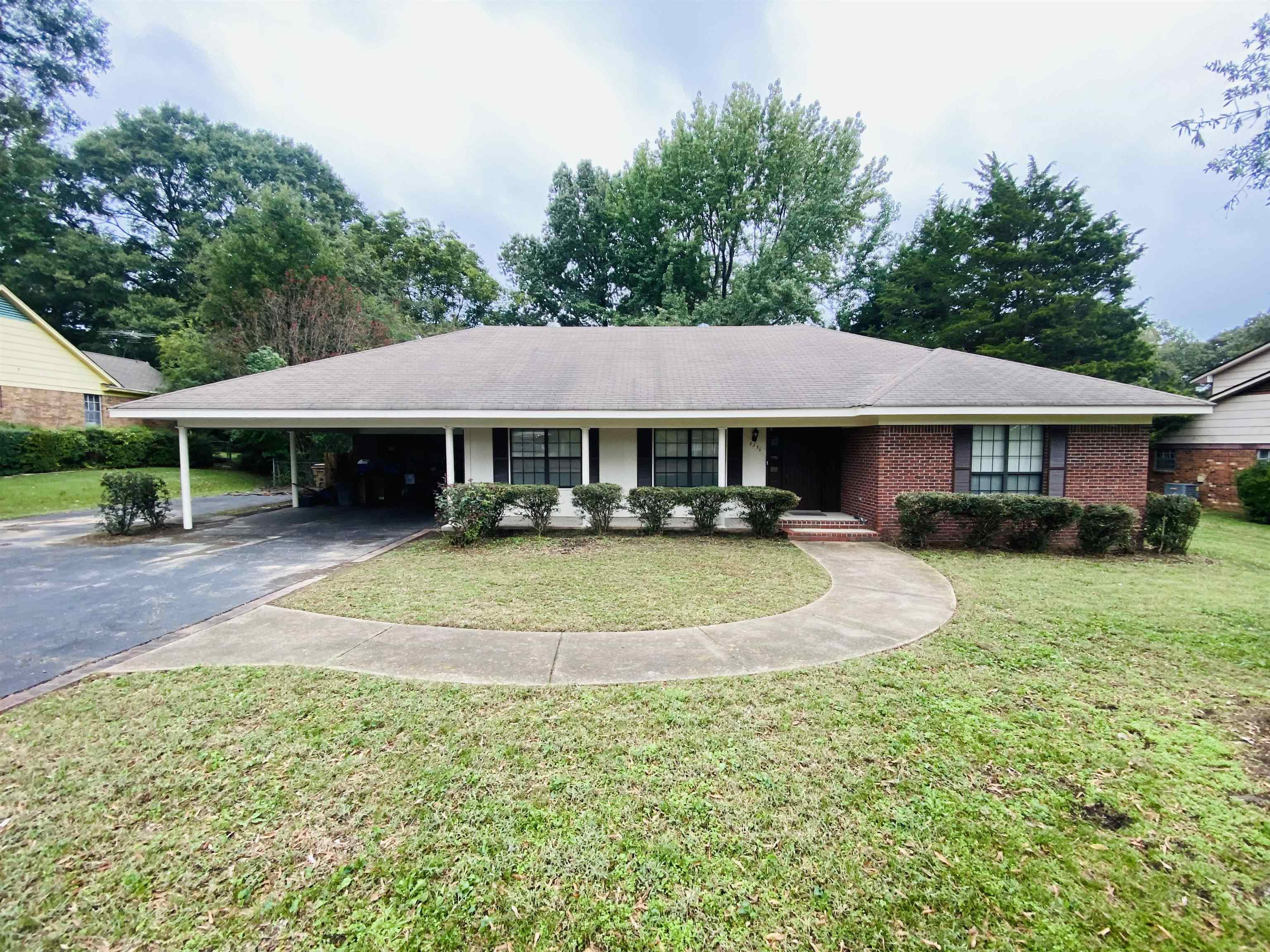 View of front of house featuring a carport and a front lawn