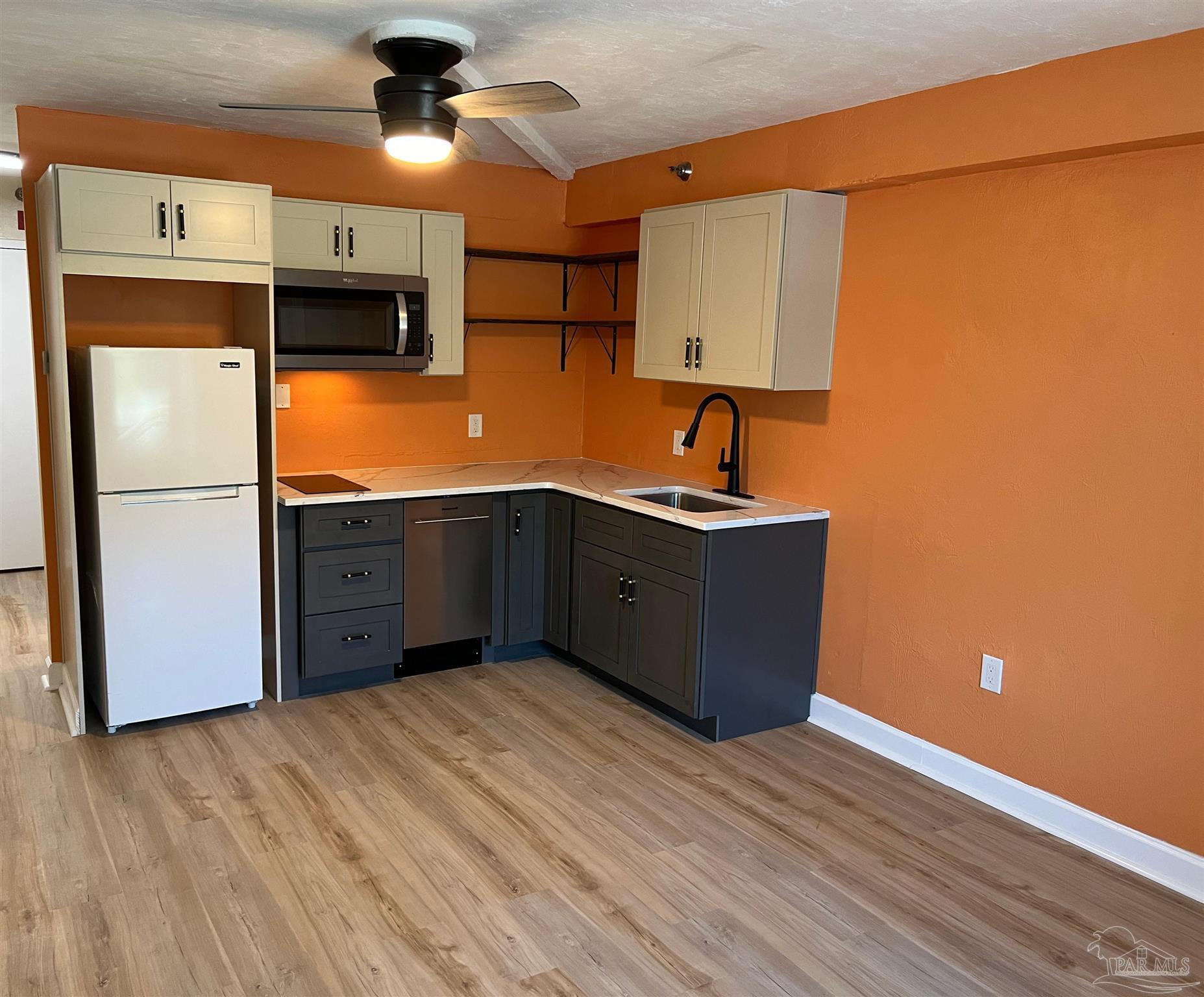 a kitchen with stainless steel appliances granite countertop a sink refrigerator stove and microwave