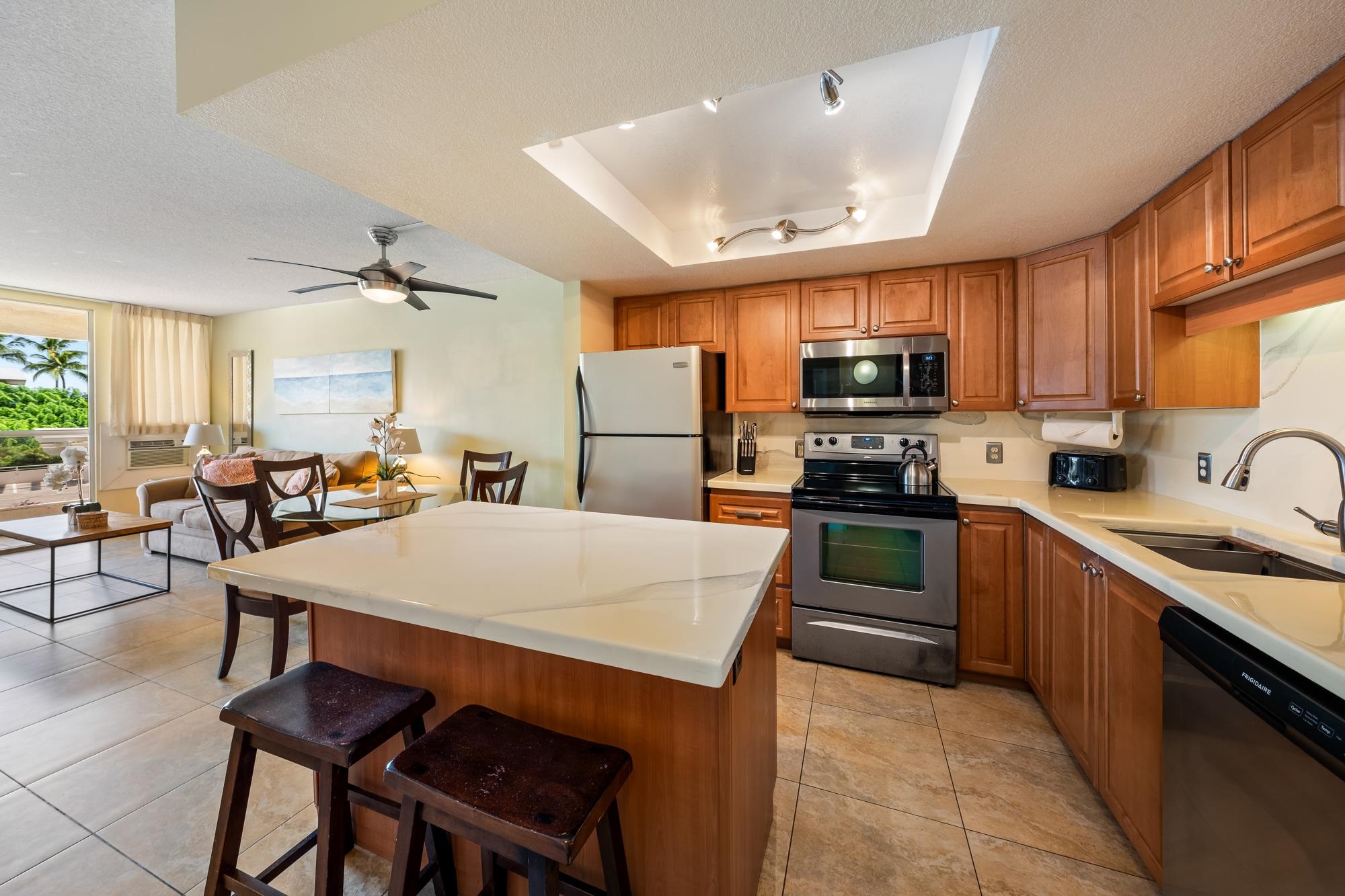 a kitchen with stainless steel appliances a table chairs sink refrigerator and cabinets