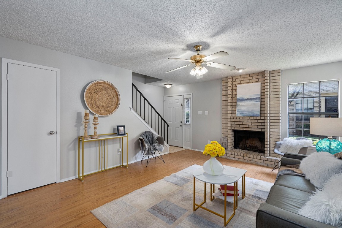 Imagine relaxing in this spacious living room that features a wood burning fireplace and a walk in closet underneath the stairs.