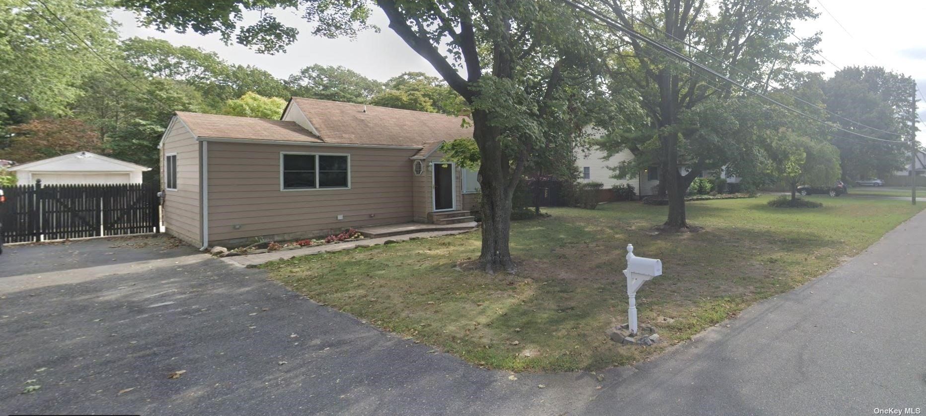 a backyard of a house with trees and wooden fence