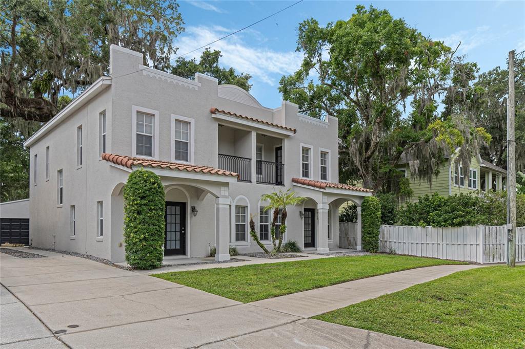 a view of a white house with a yard and plants