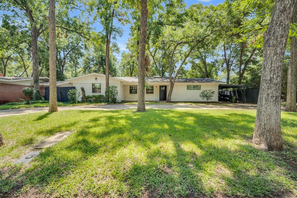 a view of a house with a big yard and sitting area