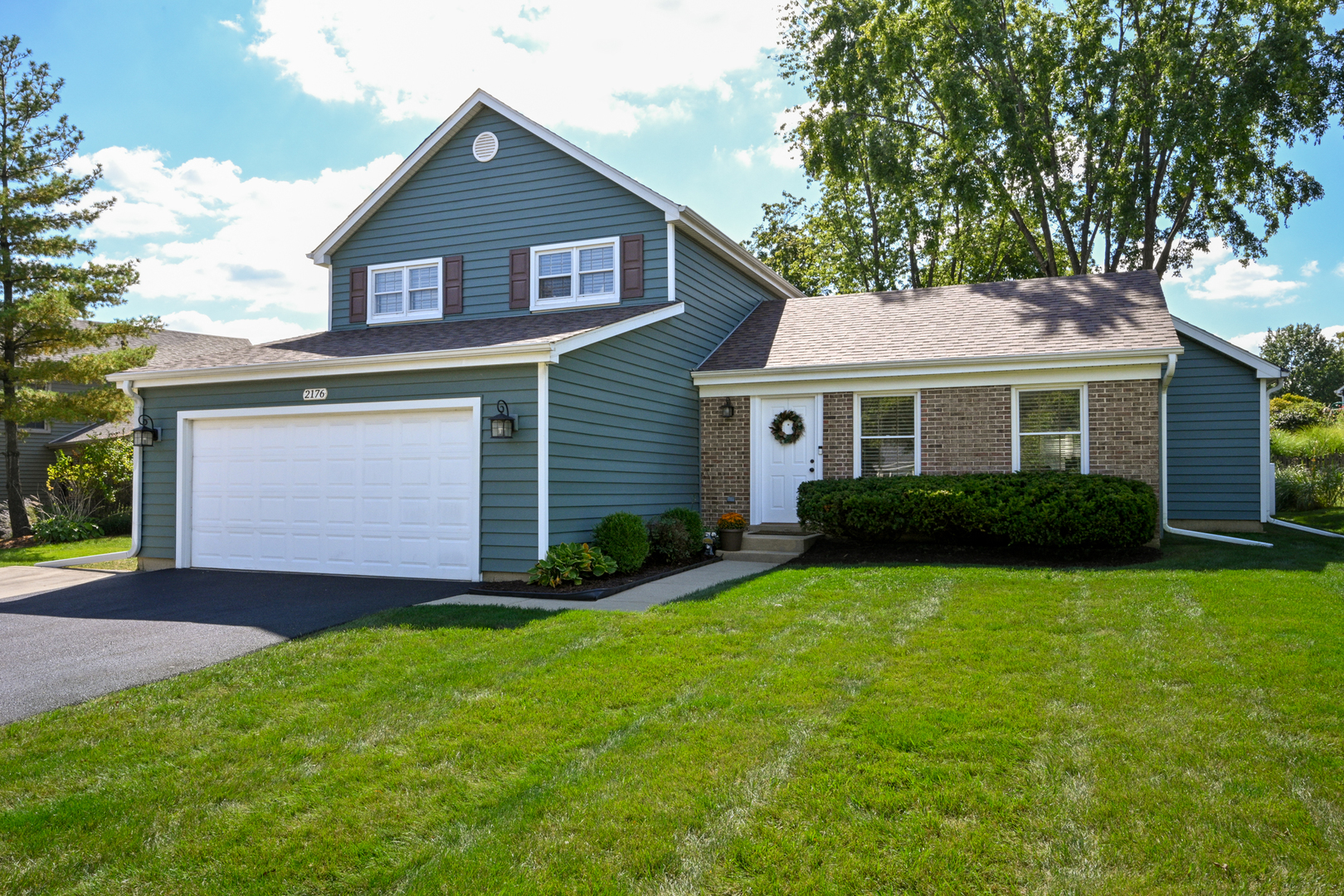 a front view of a house with a garden and yard