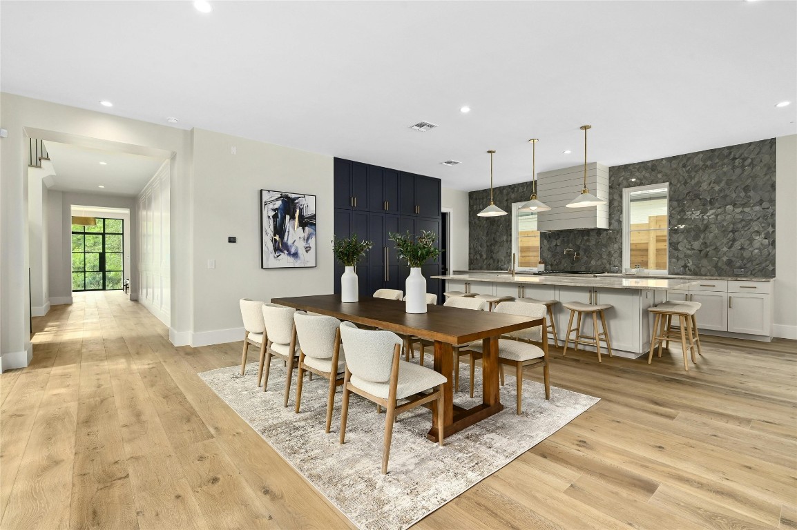 a living room with couches a coffee table and kitchen view with wooden floor