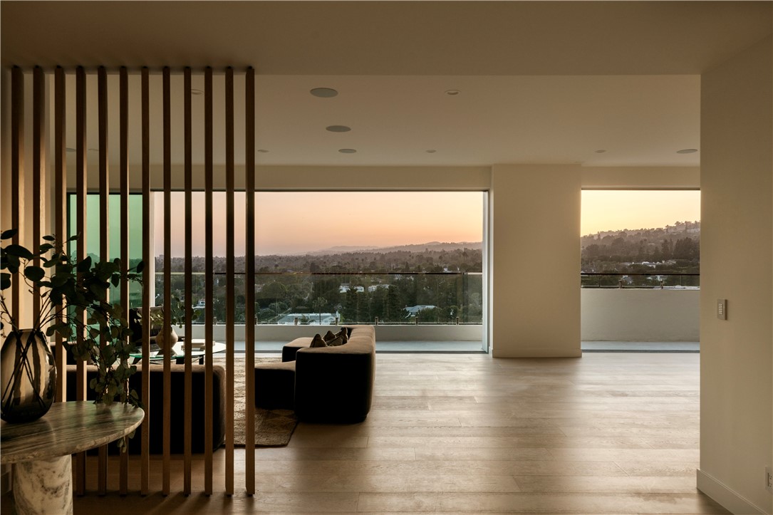 a view of a living room and floor to ceiling window and wooden floor