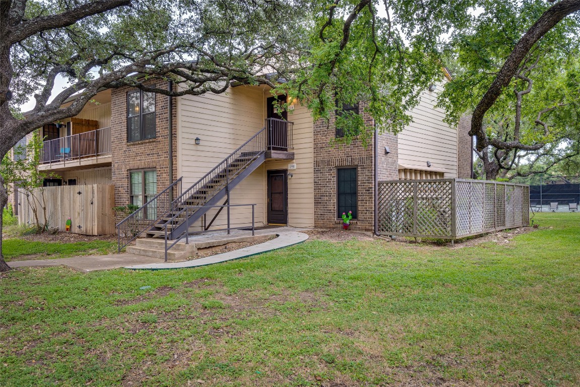 a view of a house with backyard and a tree