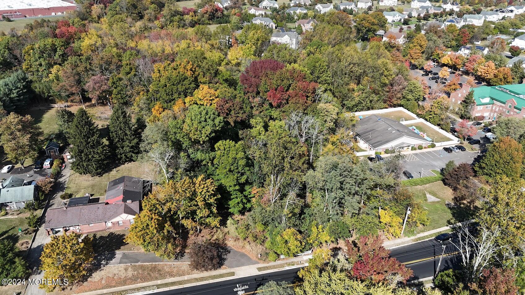 an aerial view of residential house with outdoor space and trees all around