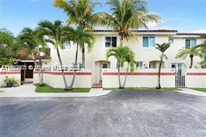 a view of a house with a yard and palm trees