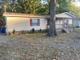 a view of a house with backyard and a tree