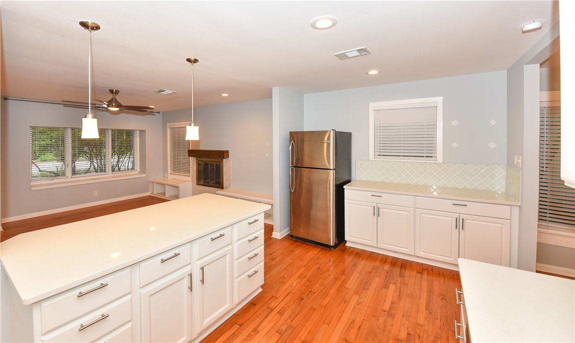 a kitchen with a refrigerator a sink and cabinets