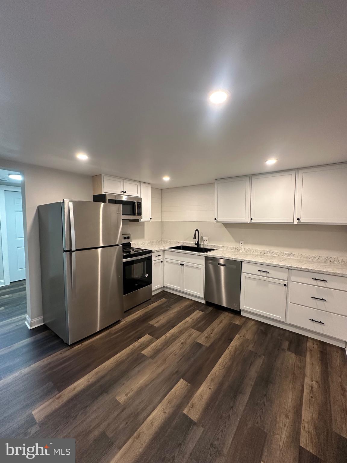 a kitchen with stainless steel appliances a refrigerator and a stove top oven