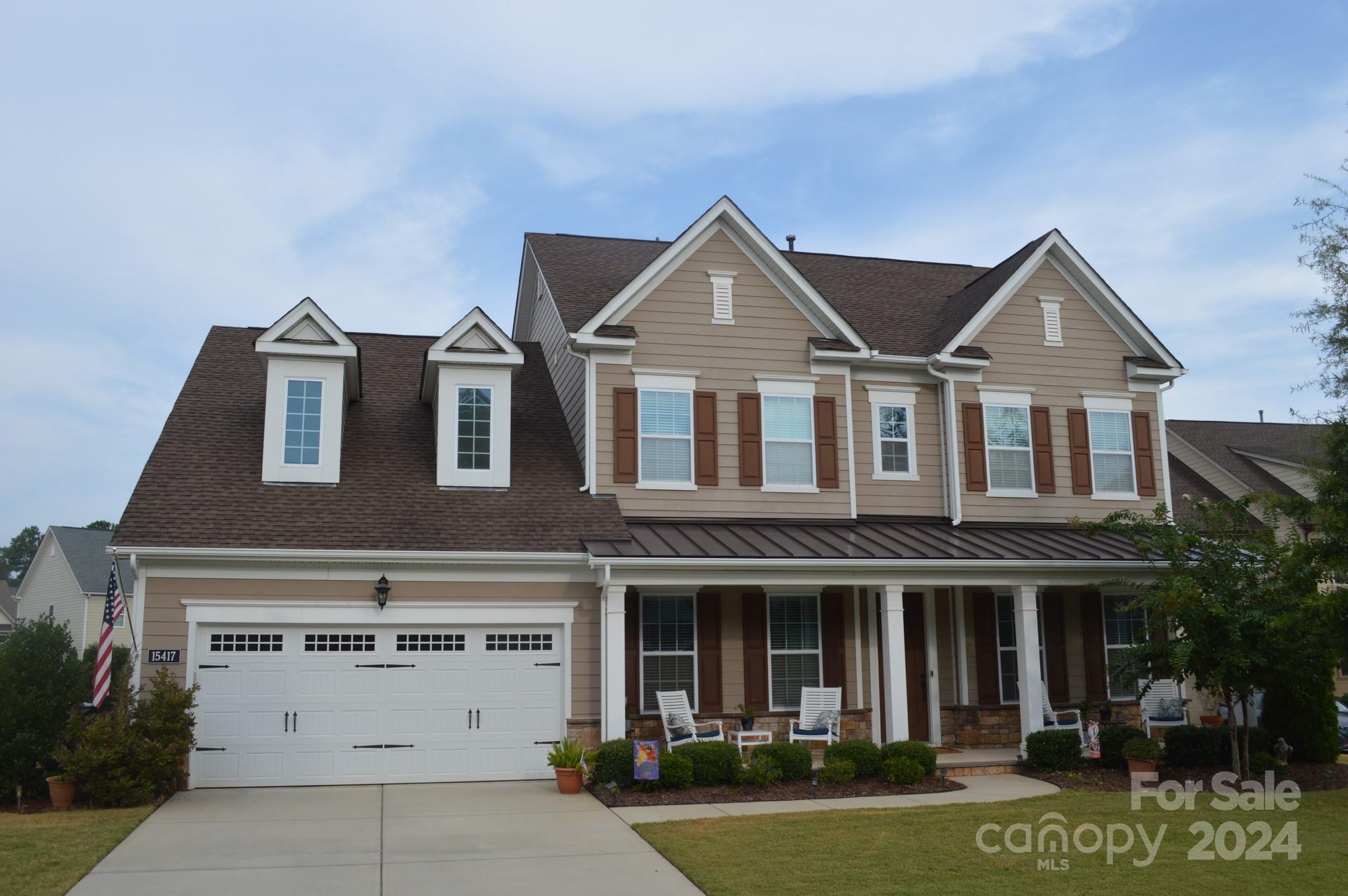 a front view of a house with yard and garage