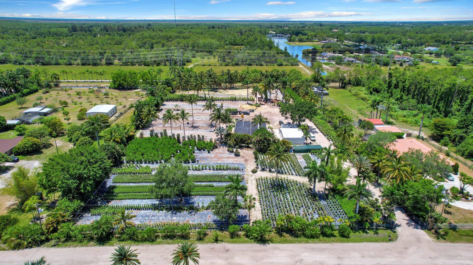 an aerial view of residential houses with outdoor space and trees