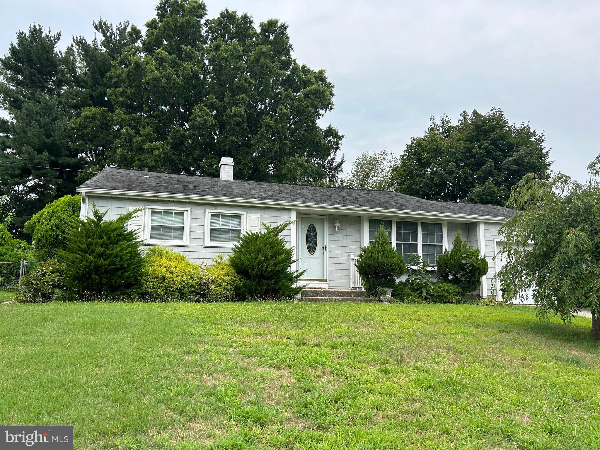 a front view of a house with a yard and potted plants