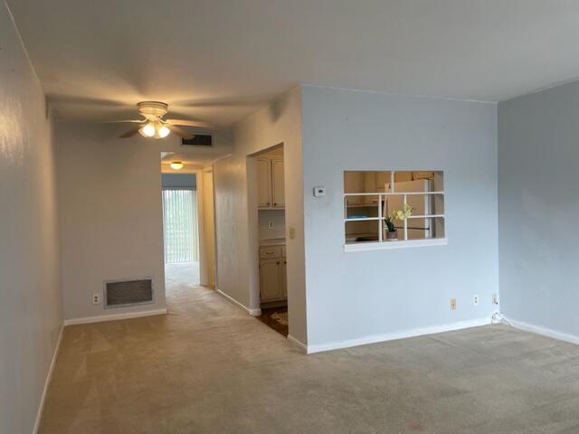 a view of a livingroom with a ceiling fan and window