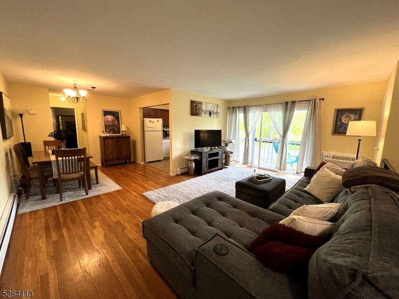 a living room with furniture and a flat screen tv with kitchen view