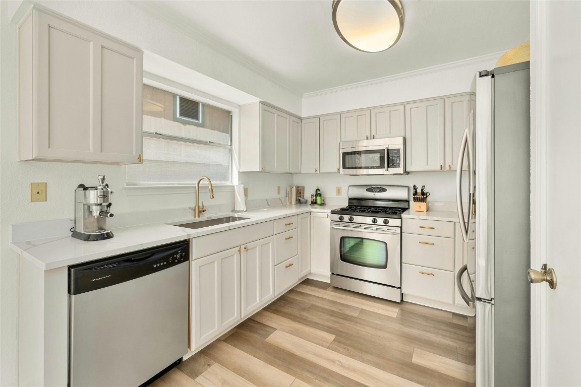 a kitchen with cabinets stainless steel appliances and a sink