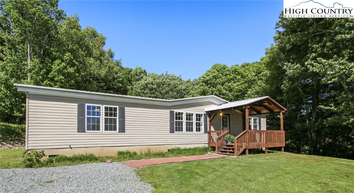 a front view of a house with a yard and tree