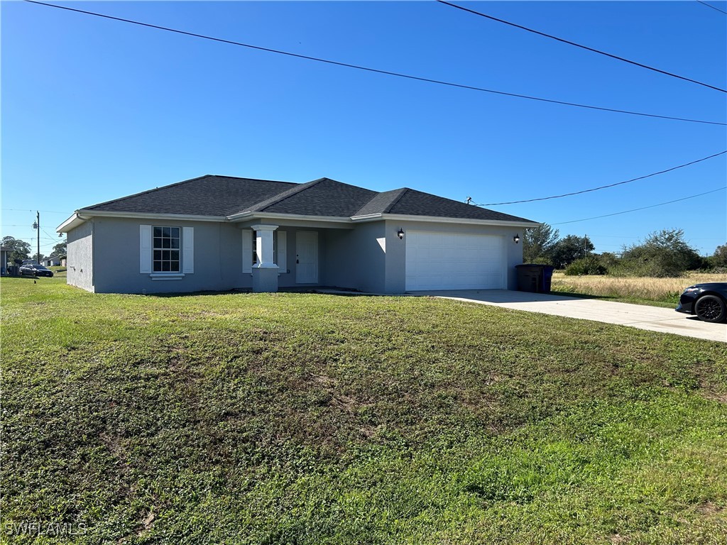 a front view of house with yard and garage