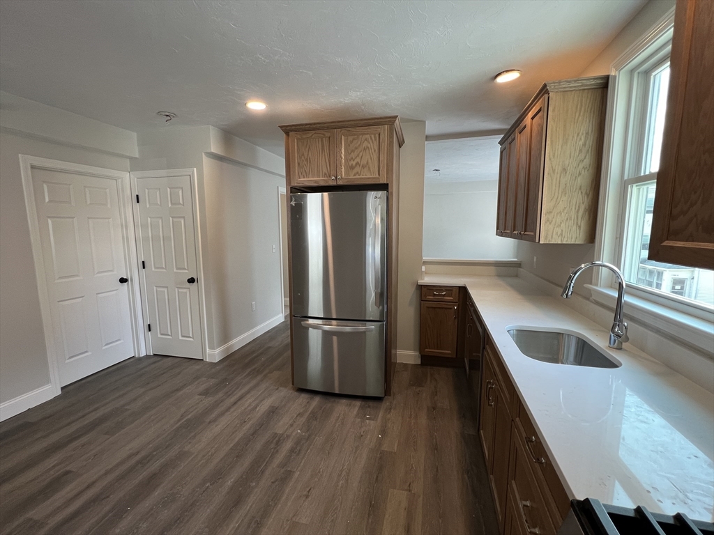 a kitchen with a refrigerator sink and wooden floor